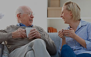 Older adult and caregiver sharing a conversation, representing assisted living support at Moose Lake Village.