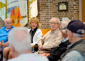 Residents gathered for a group discussion, representing chapel services and spiritual life opportunities at Moose Lake Village.