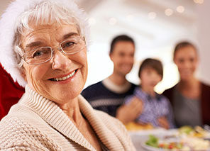 Older adult with family members in the background, representing family events and gatherings at Moose Lake Village.