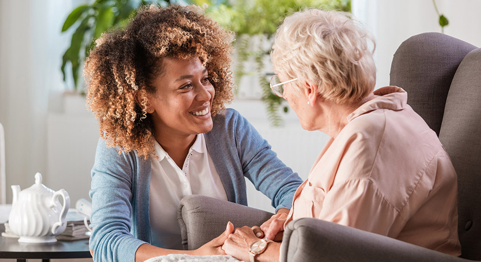 Caregiver spending time with an older adult, representing compassionate long-term care at Moose Lake Village.