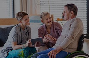 Person visiting with older adults in a community setting, representing support funded through the Greatest Need program at Moose Lake Village.