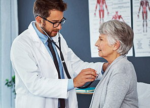 Medical professional providing care to an older adult, representing access to hospital and health care services through Moose Lake Village.