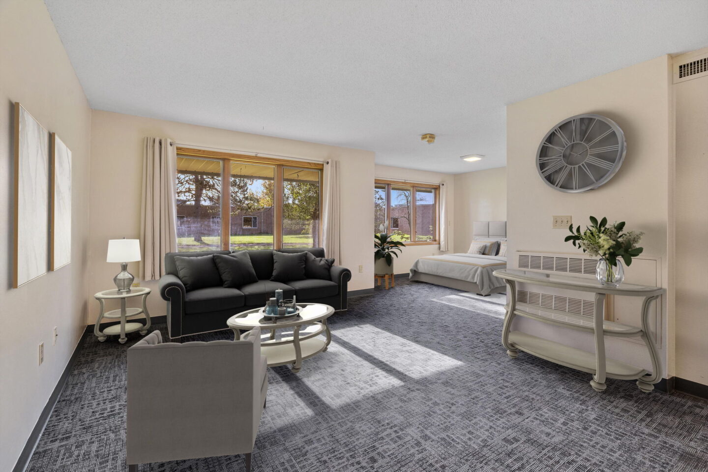 Studio apartment home with living area, sleeping space, and large windows at Kenwood Assisted Living in Moose Lake, Minnesota.