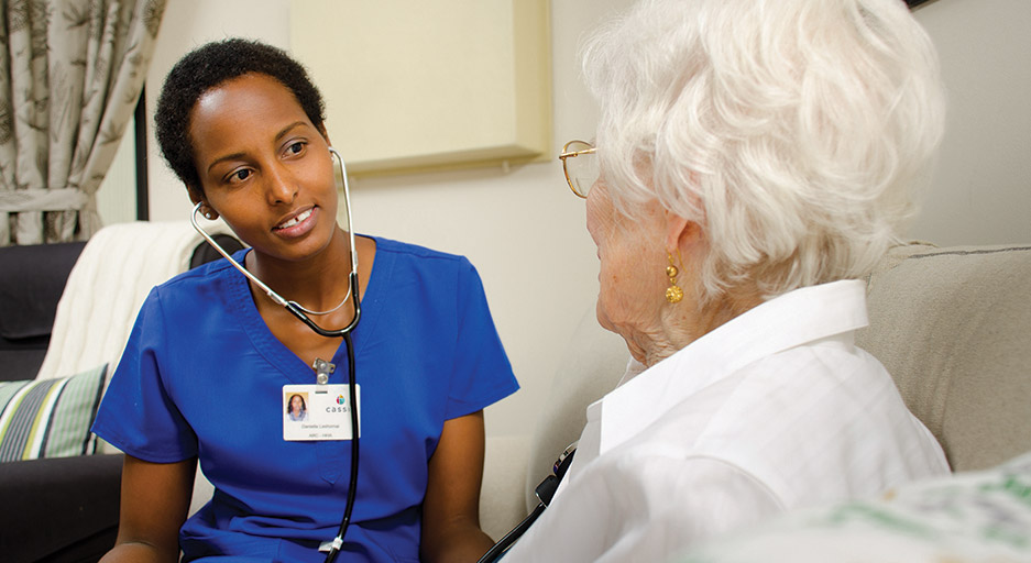 Care team member visiting with an older adult, representing 24-hour skilled nursing services at Moose Lake Village.
