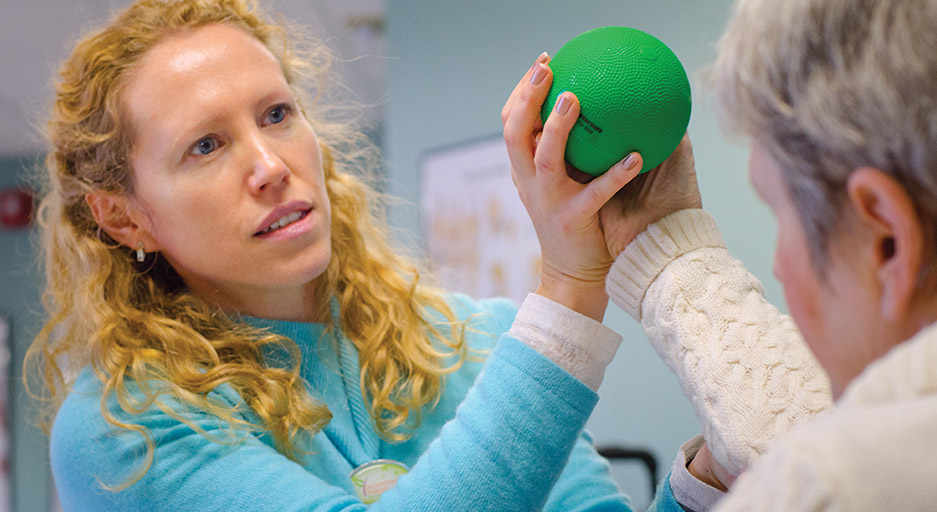 Therapist guiding an older adult through a rehabilitation exercise, representing occupational therapy at Moose Lake Village.