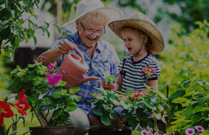 Older adult and child gardening outdoors, representing outdoor spaces and nature experiences at Moose Lake Village.