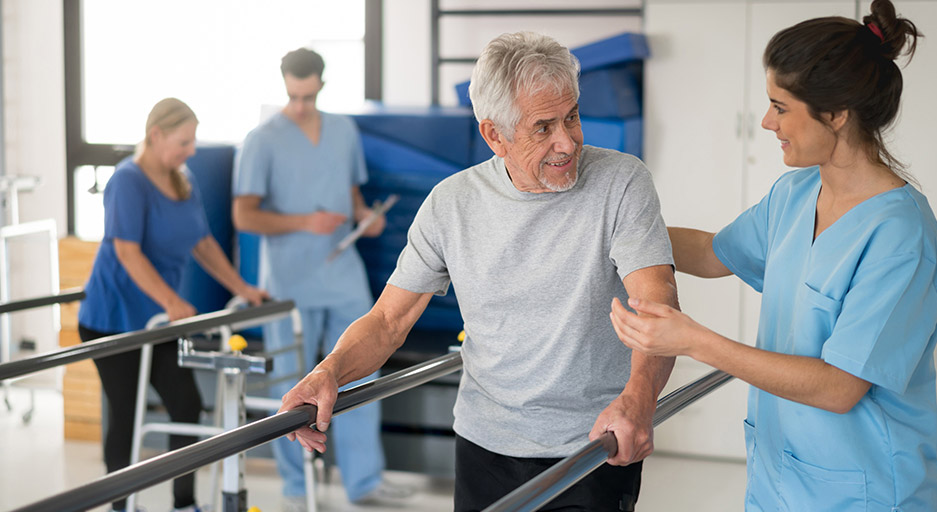 Therapist assisting an older adult with mobility training, representing short-term rehabilitation and recovery at Moose Lake Village.