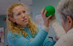 Therapist assisting a rehabilitation patient with strength and mobility exercises, representing short-term rehabilitation at Moose Lake Village.