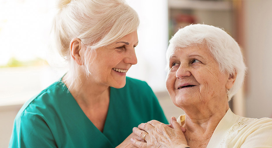 Caregiver providing personalized support to an older adult, representing long-term skilled nursing care at Moose Lake Village.
